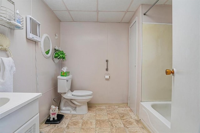 bathroom with a drop ceiling, toilet, and vanity