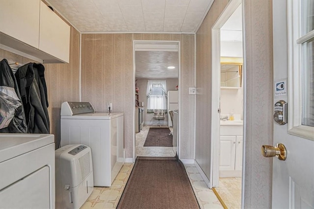 washroom featuring baseboards, independent washer and dryer, and laundry area