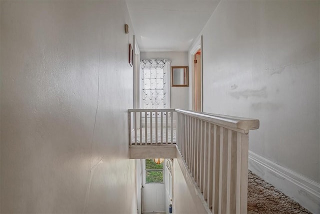 stairway with plenty of natural light and baseboards