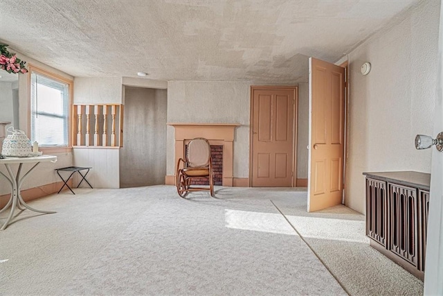 living area with carpet flooring, a textured wall, and a textured ceiling