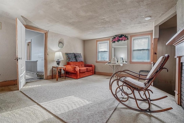 living area with baseboards, carpet floors, a fireplace, and a textured wall