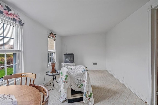 living area featuring light floors, visible vents, and baseboards