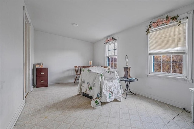 bedroom with baseboards and light floors