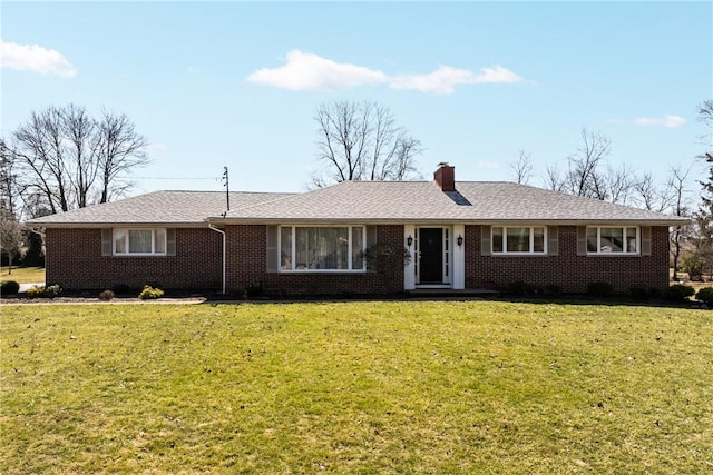 ranch-style home featuring brick siding, a chimney, and a front lawn