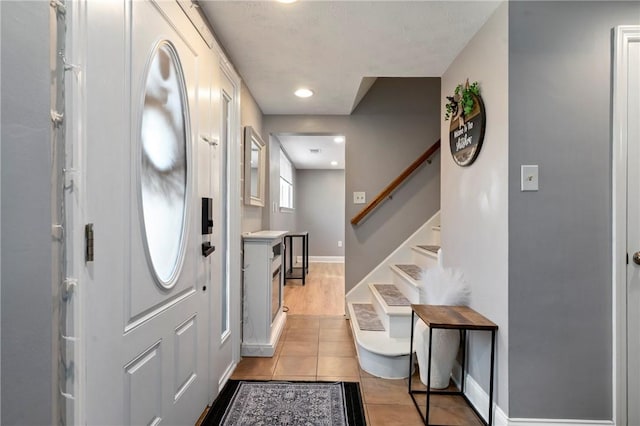 entryway featuring stairs, light tile patterned flooring, recessed lighting, and baseboards