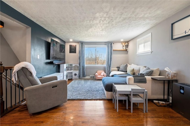 living area featuring wood finished floors and a textured ceiling