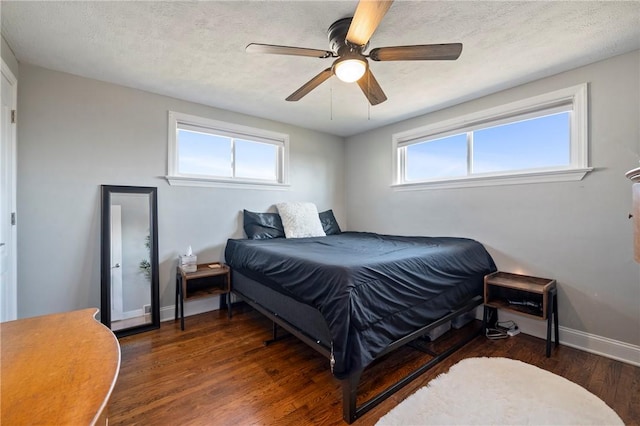 bedroom featuring baseboards, a textured ceiling, wood finished floors, and a ceiling fan