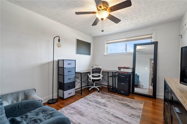 office space featuring a ceiling fan, wood finished floors, baseboards, and a textured ceiling