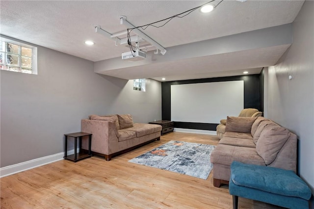 cinema room with recessed lighting, baseboards, a textured ceiling, and light wood-style flooring