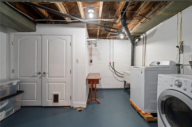 washroom featuring laundry area, independent washer and dryer, and concrete block wall