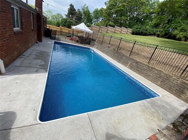 view of pool with a patio, a fenced backyard, a fenced in pool, and a lawn