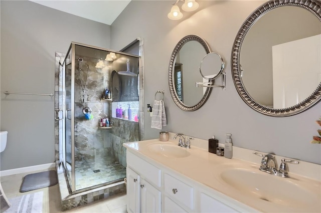 bathroom with double vanity, a stall shower, tile patterned floors, and a sink