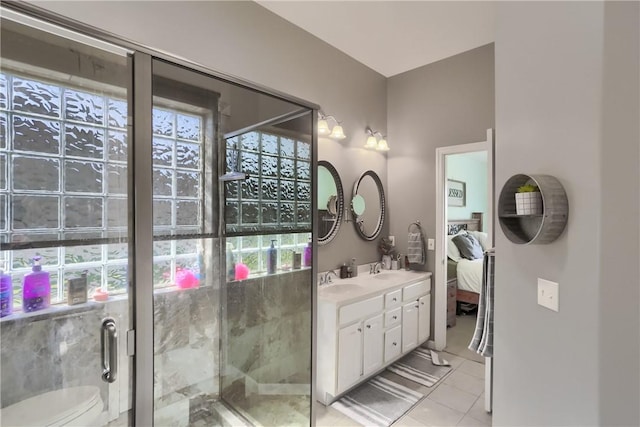 ensuite bathroom with tile patterned floors, toilet, a sink, a shower stall, and double vanity