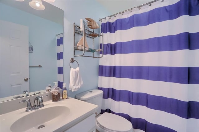 full bath with a shower with curtain, toilet, and vanity