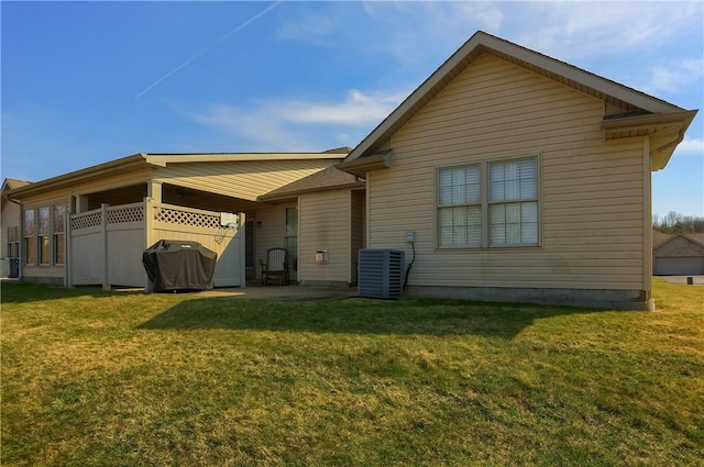 rear view of house with a lawn, central AC unit, and a patio area