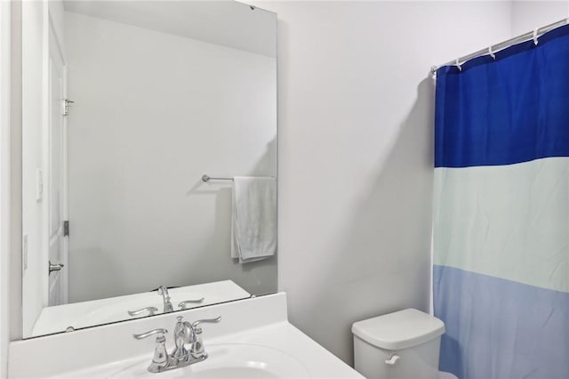 full bath featuring vanity, a shower with shower curtain, and toilet