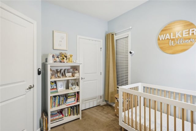 carpeted bedroom featuring a crib