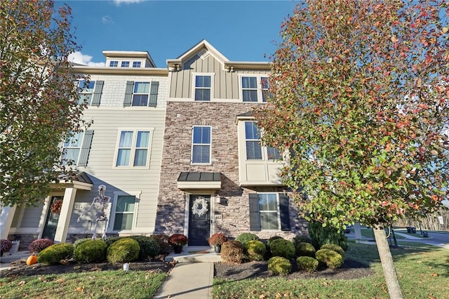 townhome / multi-family property featuring board and batten siding and stone siding