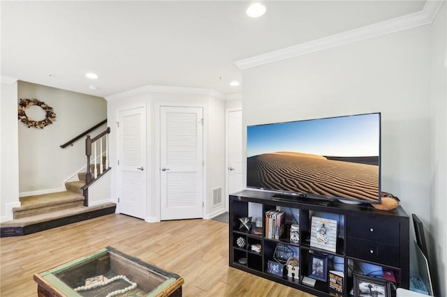 interior space with wood finished floors, visible vents, recessed lighting, stairs, and crown molding