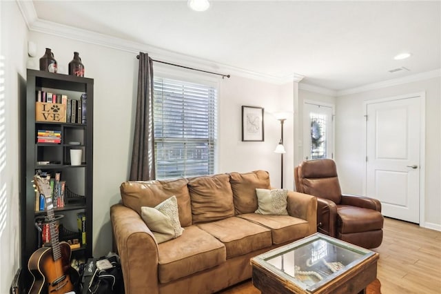 living room featuring visible vents, light wood-type flooring, and ornamental molding