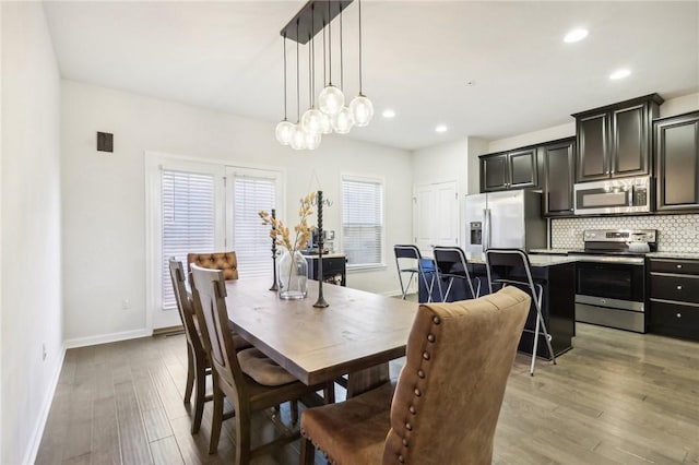 dining area with an inviting chandelier, recessed lighting, baseboards, and light wood-style floors