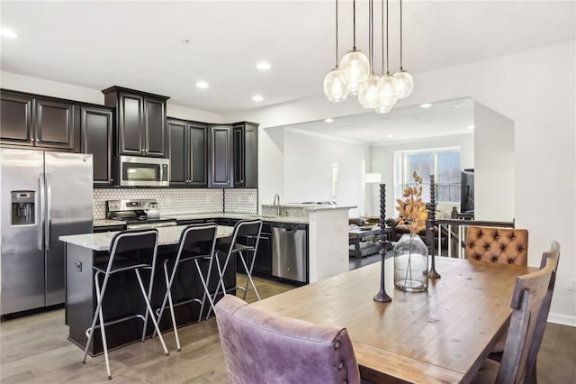 dining area featuring recessed lighting, baseboards, light wood-type flooring, and an inviting chandelier