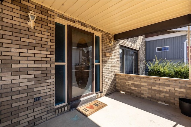 entrance to property featuring brick siding