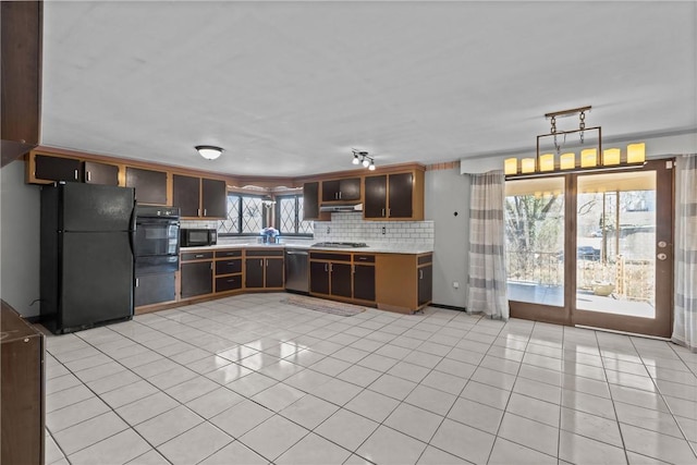 kitchen with decorative backsplash, black appliances, light tile patterned floors, and light countertops