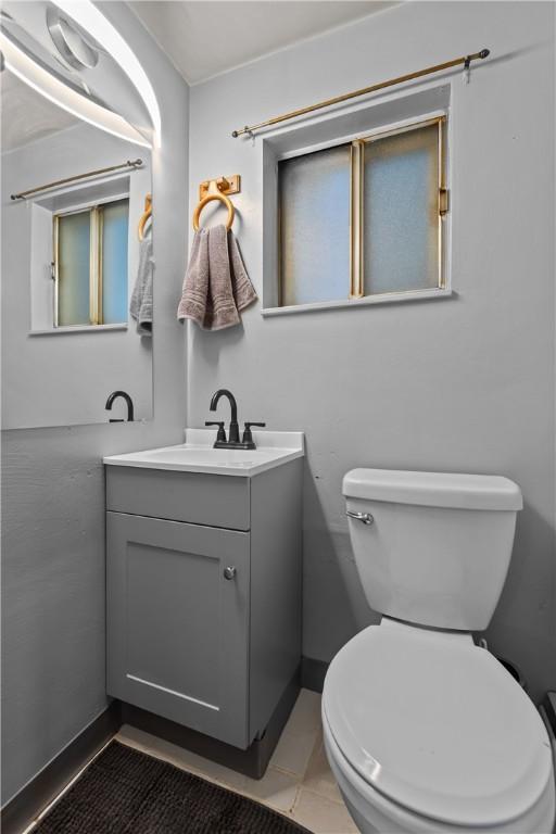 bathroom featuring vanity, toilet, and baseboards