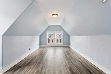 bonus room featuring baseboards, wood finished floors, and vaulted ceiling