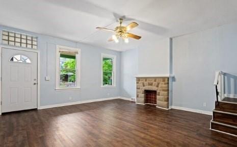 unfurnished living room featuring baseboards, wood finished floors, ceiling fan, and stairs