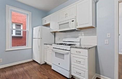 kitchen with white appliances, white cabinets, baseboards, and backsplash