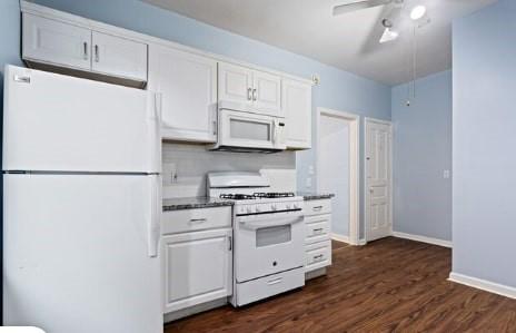 kitchen with baseboards, dark wood finished floors, white appliances, white cabinetry, and a ceiling fan