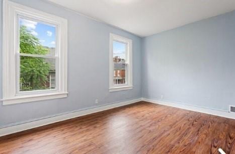 spare room with wood finished floors and baseboards