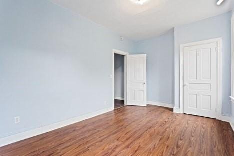 unfurnished bedroom with baseboards and wood finished floors