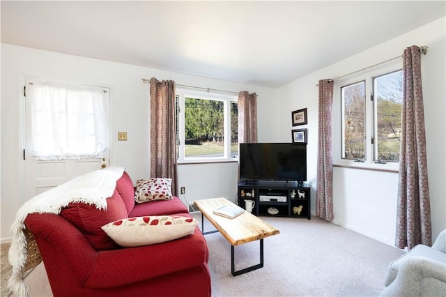 living area with baseboards and light carpet