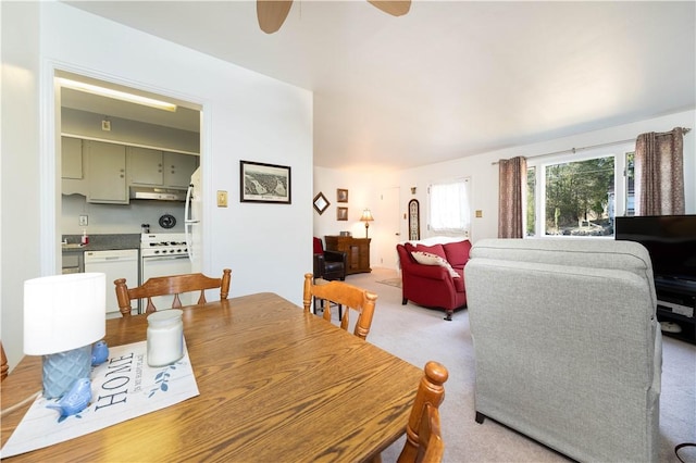 dining area featuring light carpet and a ceiling fan