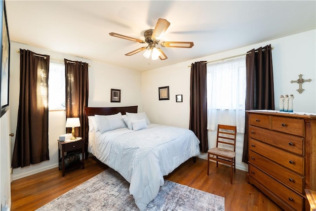 bedroom with multiple windows, wood finished floors, and ceiling fan