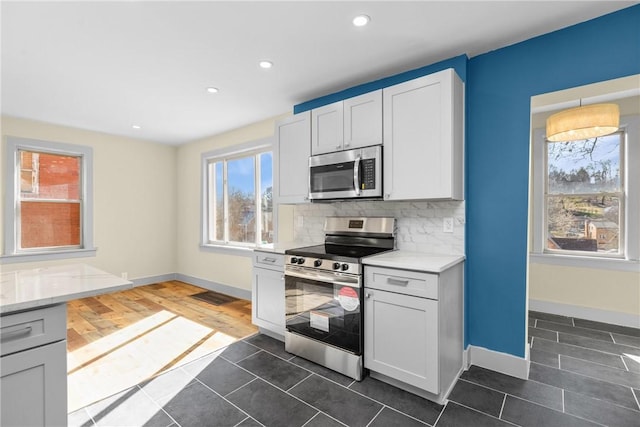 kitchen with recessed lighting, tasteful backsplash, appliances with stainless steel finishes, and light countertops