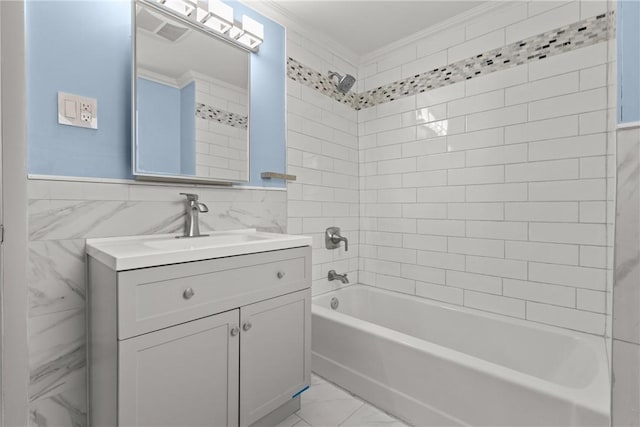 full bath with tile walls, crown molding, marble finish floor, vanity, and  shower combination