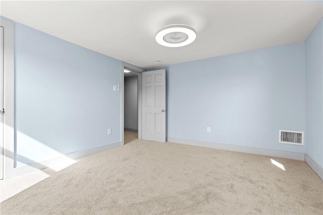 carpeted spare room featuring visible vents and baseboards