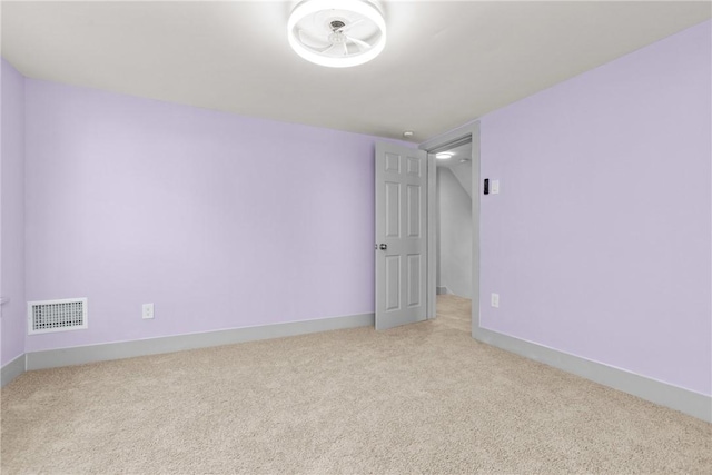 spare room featuring baseboards, visible vents, and light carpet