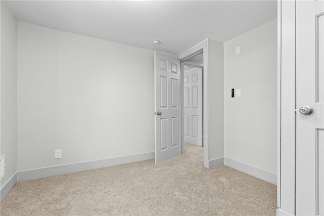 unfurnished bedroom with baseboards and light colored carpet