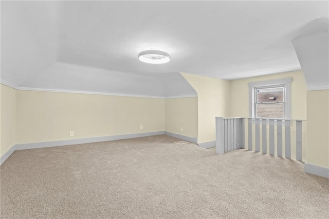 bonus room with baseboards and carpet