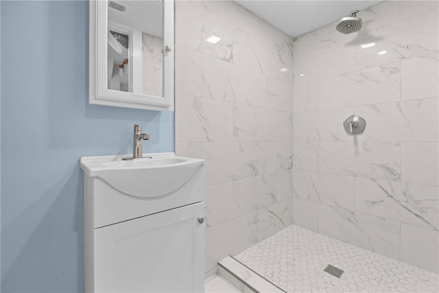 bathroom featuring vanity, visible vents, and a tile shower