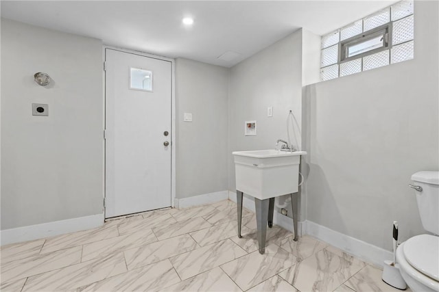 bathroom with baseboards, toilet, and marble finish floor