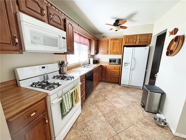 kitchen featuring brown cabinets, a sink, white appliances, light countertops, and ceiling fan