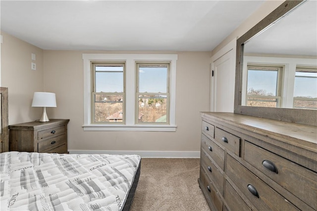 carpeted bedroom featuring multiple windows and baseboards