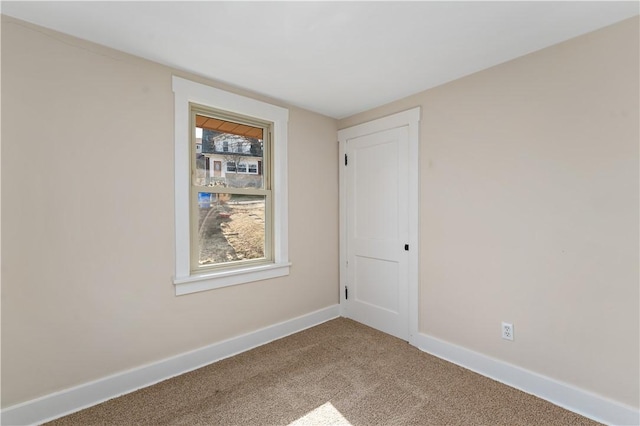 unfurnished room with baseboards and carpet floors