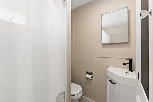 bathroom with a shower with shower curtain, toilet, tile walls, and vanity